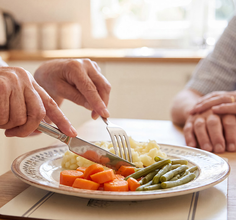 Une personne coupe des aliments dans une assiette